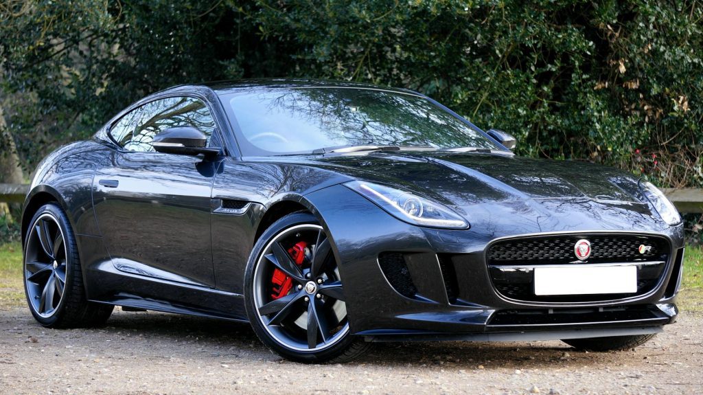 Black Jaguar F-Type sports car elegantly parked outdoors on a sunny day.